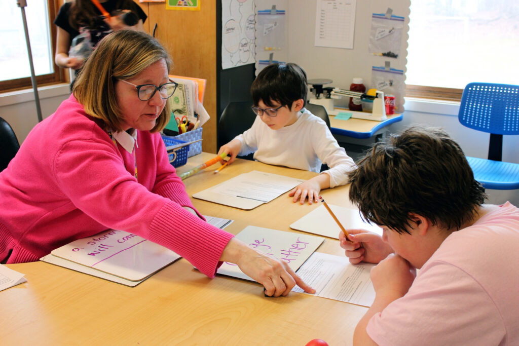 A teacher at Clearpool campus helps a student through a small group task, an important part of the EDI teaching model.